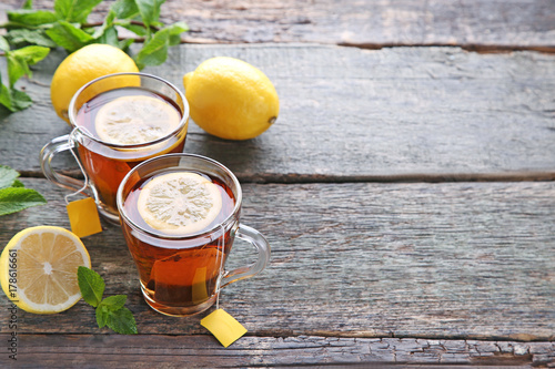 Cup of tea with teabag and lemon on wooden table