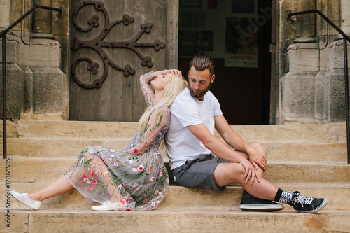 londe girl and Hipster handsome man with beard hugging and kissing on the city streets