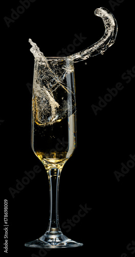 Glass of champagne with splashes on a black background