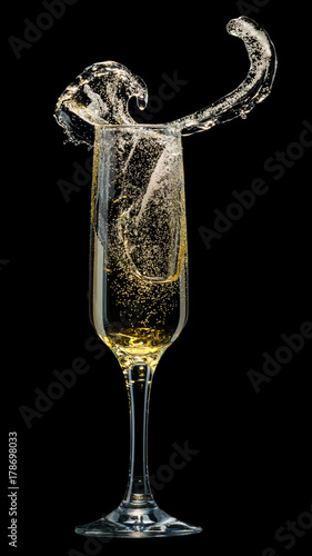 Glass of champagne with splashes on a black background