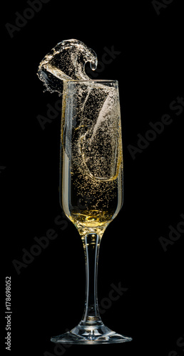 Glass of champagne with splashes on a black background