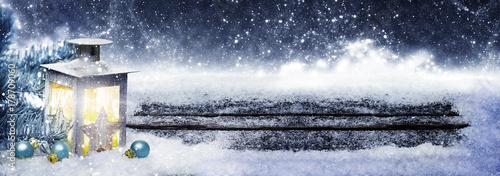 Laterne und Kugeln am Weihnachtsbaum im Schnee