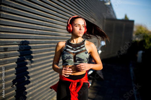 Active young beautiful woman running in urban enviroment