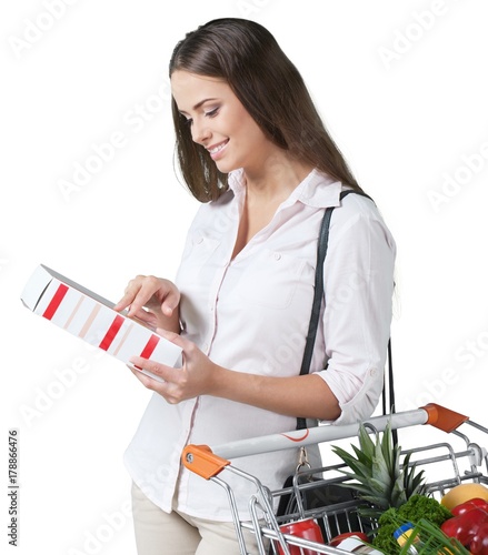 Portrait of a Woman Checking Food Labelling with Shopping Cart