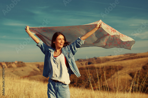 Young woman holding a scarf in the wind on a mountain