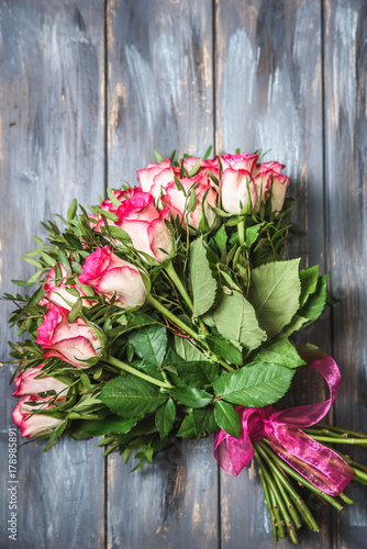 Fototapeta Pink roses bouquet over wooden table. Top view with copy space
