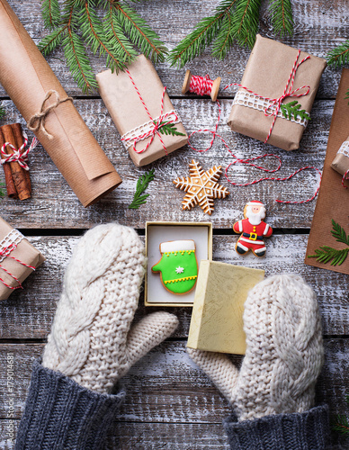 Woman  in mittens packing Christmas gift boxes