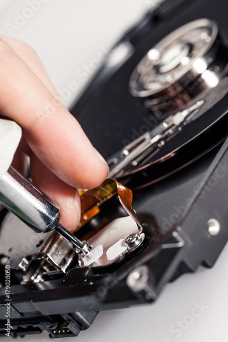 Closeup of a Hand Working on a Hard Disk Drive