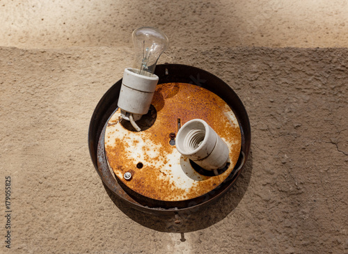 Tungsten lamp on an old wall.