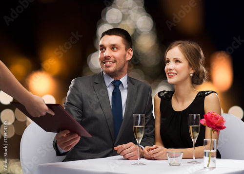 couple taking menu at christmas restaurant