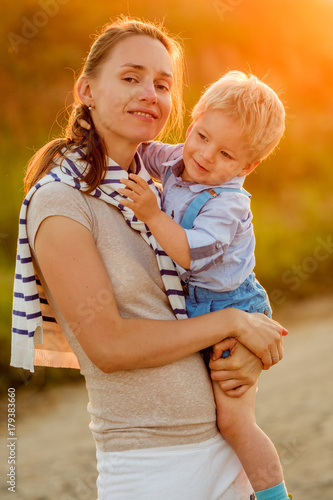 Woman and child having fun outdoors in sunset sunlight