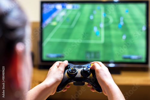 Zdjęcie XXL Zakończenie kobieta wręcza trzymać joysticka kontrolera podczas gdy bawić się wideo gry w domu, wąska głębia pole na rękach