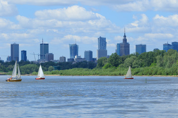 Warsaw skyline with downtown skyscrapers and three sailboats on the Vistula river