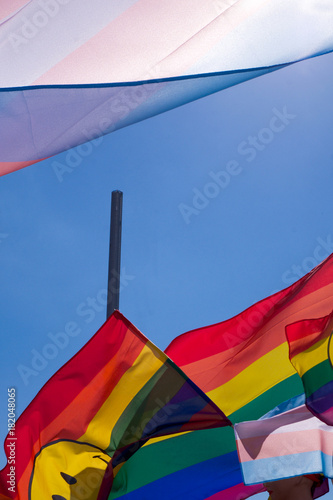 Plakat tęczowe kolorowe flagi pływające w błękitne niebo ze słońcem świeci przez