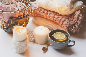 Cozy winter morning at home. Hot tea with lemon, knitted sweaters and modern metallic interior details. Still life composition, danish hygge concept