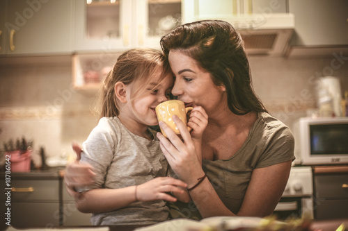 Фото: Mother and daughter have fun together. Mommy let me try coffee. Mother and daughter have fun together. Mommy let me try coffee.
