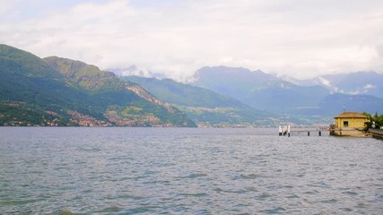 A Small boathouse on Lake Como in Italy with mountains in the background.