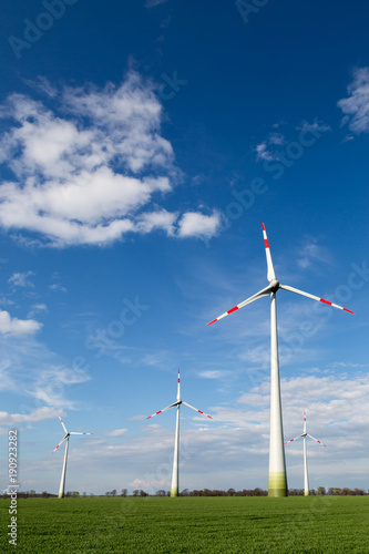 Zdjęcie XXL duże wiatraki stoją na polu i produkują zieloną energię elektryczną