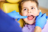 The dentist checking the teeth of boy teenager in the dentist's office.