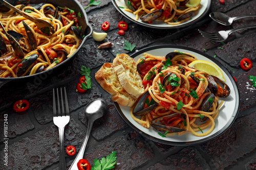 Fotoobraz na płótnie Domowej roboty makaronu spaghetti z mussels, pomidorowym kumberlandem, chili i pietruszką na nieociosanym tle ,. posiłek z owocami morza
