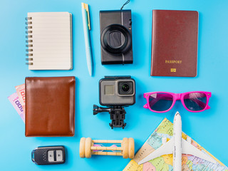 Travel accessories costumes concept for summer vacation trip. Passports, luggage, map, smartphone,sun glasses,camera, note pad, jean on blue
