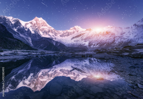 Zdjęcie XXL Nocy scena z himalajskimi górami i halnym jeziorem przy gwiaździstą nocą w Nepal. Krajobraz z wysokimi skałami z śnieżnym szczytem i niebem z gwiazdami i księżycem odbijającymi w wodzie. Moonrise Beautiful Manaslu