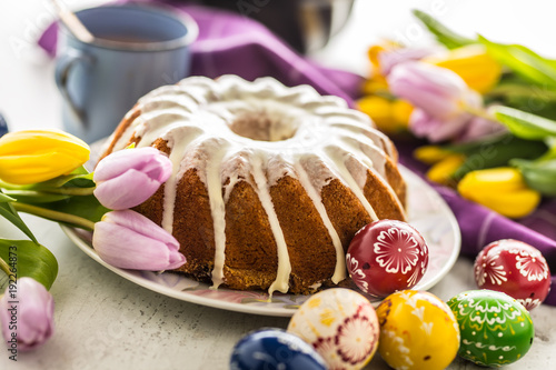 Plakat Wielkanocne ciasto. Tradycyjny ringowy marmurowy tort z Easter decotation. Pisanki i tulipany wiosna.