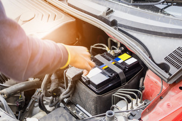 car mechanic use voltmeter to check car battery voltage level