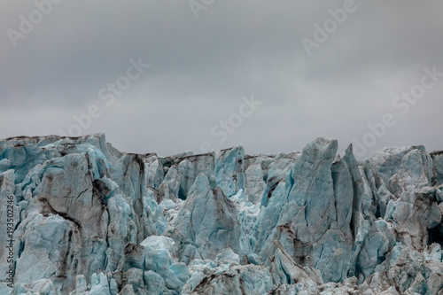 Plakat Zbliżenie lodu lodowca. Błękitny lód z chmurnym niebem above. Svalbard, Spitsbergen