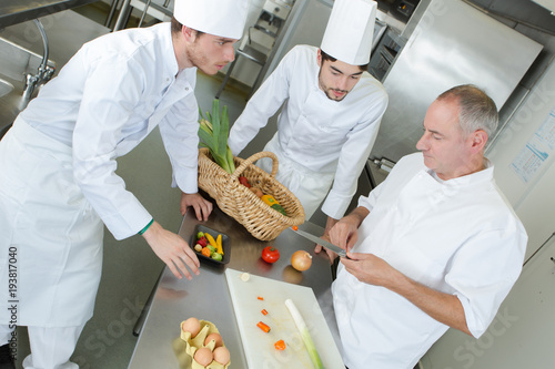 Fotoobraz na płótnie nauczyciel pomagający uczniom szkolić się w pracy w gastronomii