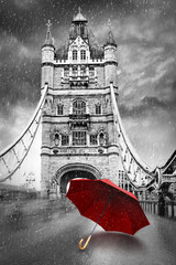 Tower Bridge on River Thames with umbrella on a raining day. London, England. Black and white concept graphic with red element.