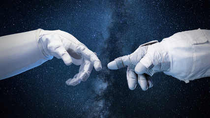 two near touching hands in space suits, 'God touches Adam' pose