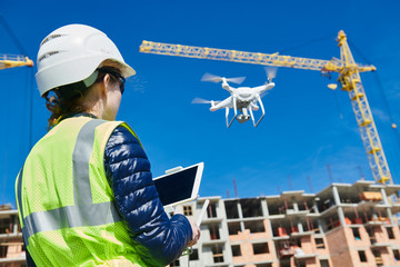 Drone inspection. Operator inspecting construction building site flying with drone