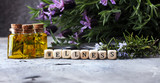 lavender oil in a glass bottle on a background of fresh flowers.