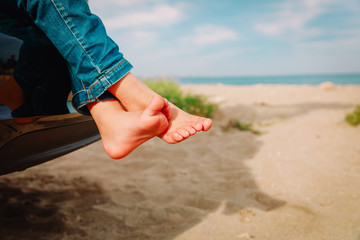 feet of little girl travel by car on beach