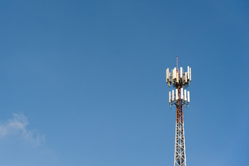 Close up white-red color antenna repeater tower on blue sky.