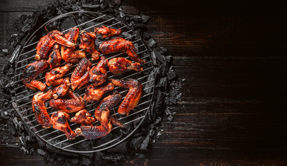 chicken wings of barbecue in honey sauce with lime slices. the dish is made and served in a rustic style