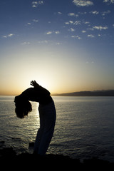 Beauty girl on beach in yoga pose, relax silhouette