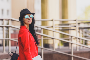 Happy hipster young woman working on laptop outdors. Student girl using laptop in university campus. Toned image.