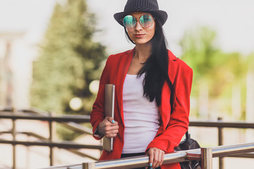 Happy hipster young woman working on laptop outdors. Student girl using laptop in university campus. Toned image.
