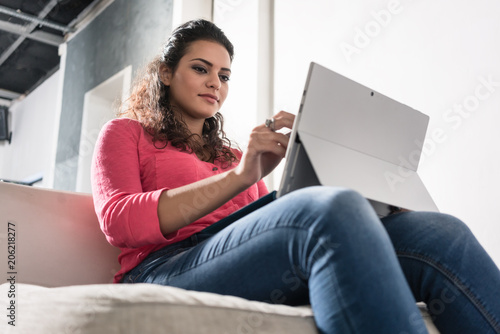 Фото: Young freelancer sitting in armchair in agency working on laptop PC Young freelancer sitting in armchair in agency working on laptop PC