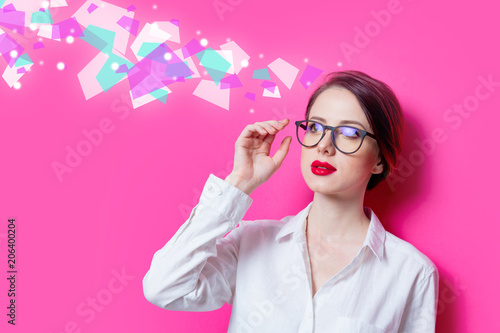 Фото: Beautiful redhead businesswoman in white shirt with abstract colored ideas on pink background Beautiful redhead businesswoman in white shirt with abstract colored ideas on pink background