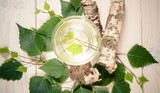A glass of birch juice on wooden background