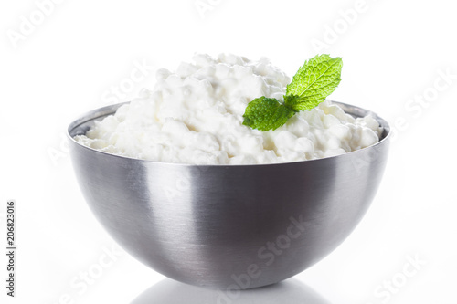Фото: Fresh cottage cheese in a metal bowl isolated on white background. Close up Fresh cottage cheese in a metal bowl isolated on white background. Close up