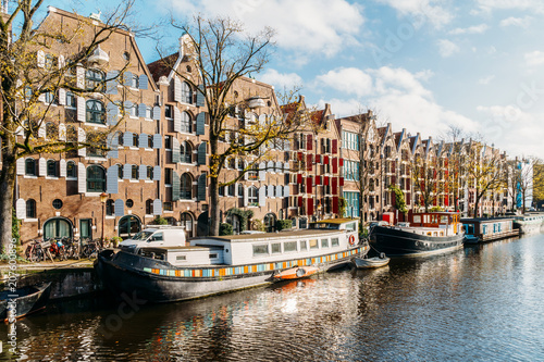 Plakat Piękna architektura holenderskich domów i łodzi na Amsterdam Canal jesienią