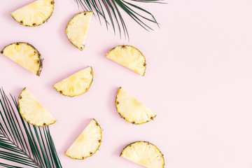 Pineapples and palm leaves on pastel pink background. Summer concept. Flat lay, top view, copy space