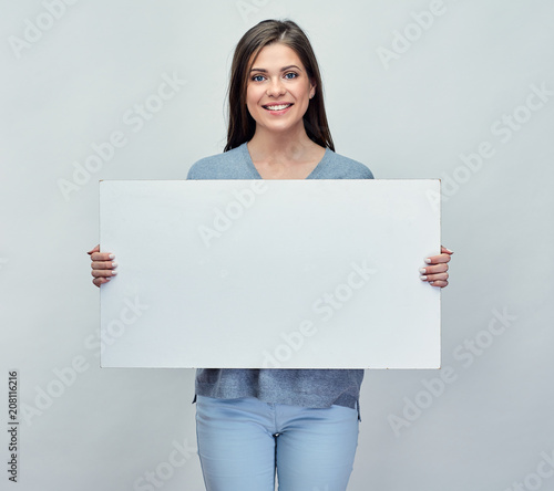 Фото: Smiling woman holding white advertising board with empty copy sp Smiling woman holding white advertising board with empty copy sp
