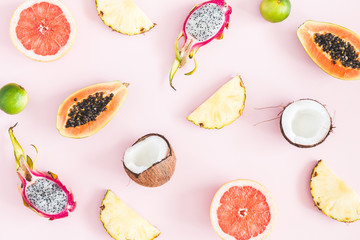 Summer fruits. Tropical pineapple, coconut, papaya, dragon fruit, orange on pastel pink background. Flat lay, top view