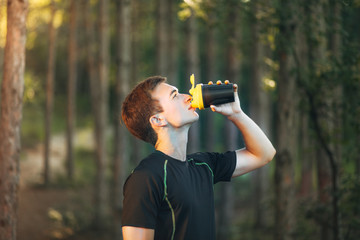 Man Drinking Water from Bottle after Running in the Park