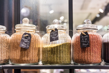 Sesame seeds in glass jars on display in a French supermarket. Paris, France